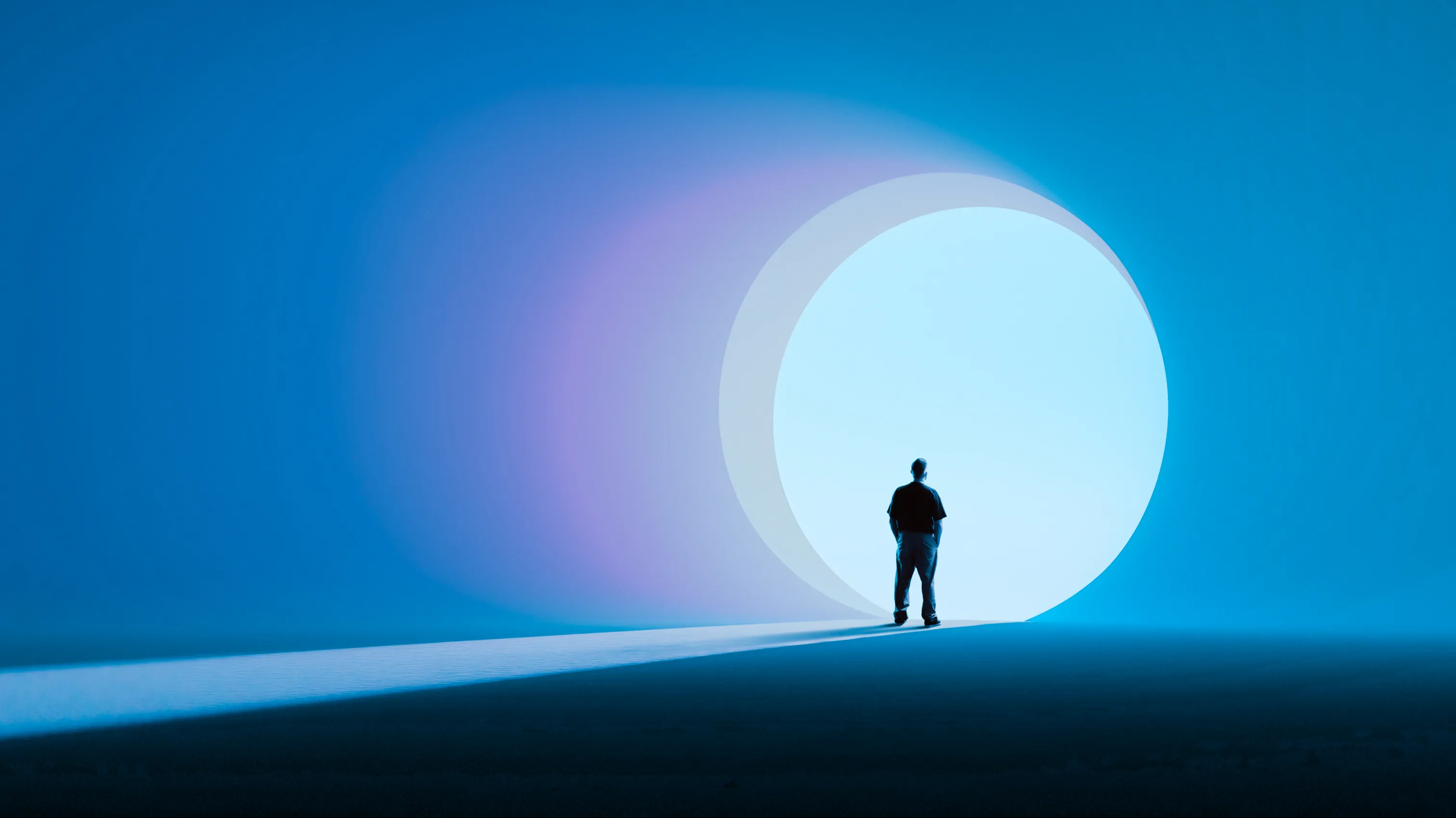 A lone figure before a glowing portal of light